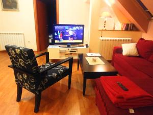 贝尔格莱德Talas apartmani的客厅配有电视、椅子和桌子