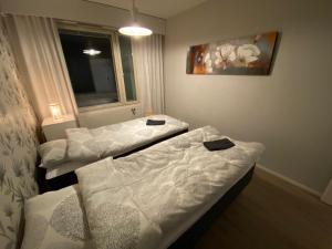 索丹屈莱Holiday Home Sodankylä的配有白色床单的客房内的两张床