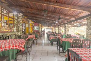 XicoOYO Hotel Coyopolan的一间空餐厅,配有红色和绿色的桌椅