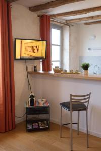 图尔尼Appartement A-Mi-Chemin - Centre-ville de Tournus的厨房配有椅子和墙上的标志