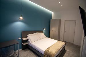 卡塔尼亚Dadà House的一间卧室配有一张蓝色墙壁的床
