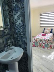 安曼约旦塔酒店的一间带水槽的浴室和一间带一张床的卧室