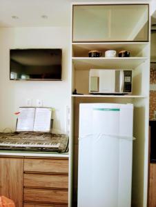 卡波布里奥Flat em Cabo Frio的厨房配有冰箱和微波炉。