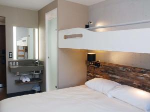 PoisyIbis Budget Annecy sud-Poisy的一间卧室配有一张双层床和白色床单