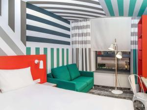 华沙ibis Styles Warszawa Centrum的一间卧室配有一张床和一把绿色椅子