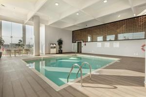 阿瓜斯卡连特斯Holiday Inn & Suites - Aguascalientes, an IHG Hotel的一座带桌椅的游泳池