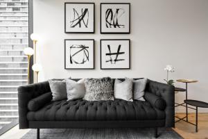 墨尔本Luxuria Apartments - Collins House的客厅配有黑色沙发和框架图片