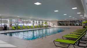 独立市克利夫兰 - 独立城南部假日酒店&度假村的一座带绿色椅子的大型游泳池