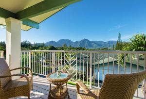 普林斯维尔Villas of Kamalii 47 home的阳台配有桌椅,享有山景。