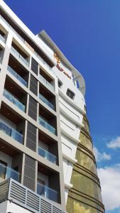 奥隆阿波Central Park Reef Resort的一座高大的白色建筑,设有阳台