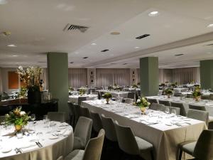托雷德尔格雷科玛拉德酒店的宴会厅配有白色的桌椅