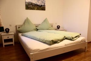 WarngauSaliterhof的一间卧室配有一张带绿色和黄色枕头的床