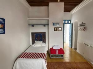舍夫沙万Casa Perleta的一间房间,配有两张床和红色的行李箱