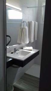 拉克鲁斯蓝之鱼公寓式酒店的浴室配有盥洗盆、镜子和毛巾