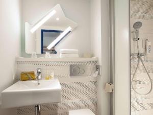 马恩河畔埃索姆ibis budget Château-Thierry的白色的浴室设有水槽和镜子