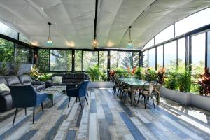 麦德林International House Co-Living的一个带桌椅和植物的温室
