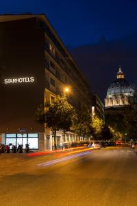 罗马星际米开朗基罗罗姆酒店的夜间的城市街道,有建筑和圆顶
