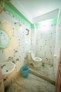 西里古里Tirupati Lodge NJP的浴室配有卫生间、盥洗盆和浴缸。