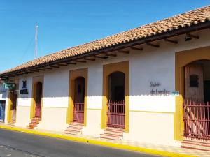 莱昂Hotel La Posada del Doctor的街道上设有黄色门和阳台的建筑