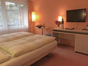 施皮茨西格腾码头酒店及餐厅 的酒店客房设有两张床和一张书桌及电视