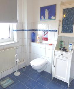 汉堡Gästezimmer im Hamburger Norden - nahe EuroFH und ILS的浴室设有白色卫生间和蓝色瓷砖。