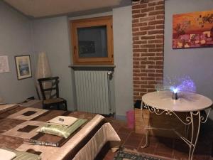 福萨诺Cascina Garaita的一间设有床铺和一张桌子的房间,上面有闪光灯