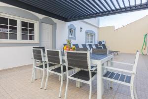 阿尔布费拉Villa Coracao Jacuzzi - 200m Beach & Sea View的庭院里的餐桌和椅子
