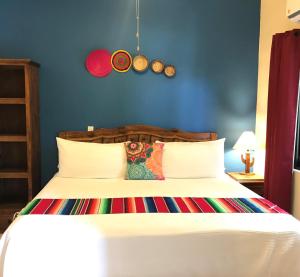 洛雷托Hotel Casa Mangos Loreto的卧室配有白色床和蓝色墙壁