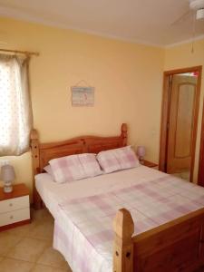 圣玛丽亚Oasis Palmeira的一间卧室配有一张大木床和白色床单