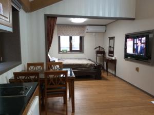 襄阳郡Sanaega Pension的客厅配有床和桌椅