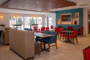 托纳万达Holiday Inn Express & Suites Tonawanda - Buffalo Area, an IHG Hotel的用餐室配有桌子和红色椅子