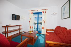 卡门港科斯塔玛尔公寓式酒店的客厅配有红色的沙发和桌子