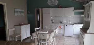 布列登maison de dunes的厨房配有桌子和桌椅
