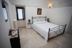 阿尔贝罗贝洛安蒂卡飞雷利亚度假屋的一间白色客房内配有一张大床的卧室