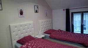 Beaumont-sur-Oise洛克公寓的一间卧室配有一张带红色床单的床和一扇窗户。