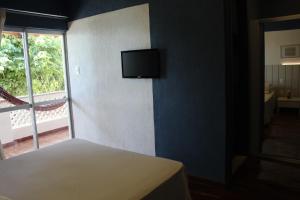 伊塔帕里卡Hotel Icaraí的一间卧室配有一张床,墙上配有电视