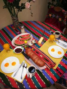 奇奇卡斯特南戈Hotel Chalet的一张桌子,上面放着鸡蛋,还有香肠和水果的早餐