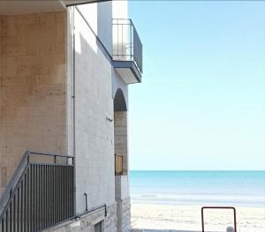 托雷坎内Blue Sea Apartment的海滩旁的一座带楼梯的建筑