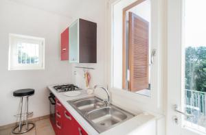圣卡特琳娜迪纳德Caper Villa的一个带水槽和窗户的小厨房