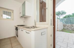 圣卡特琳娜迪纳德Caper Villa的白色的厨房设有水槽和炉灶。