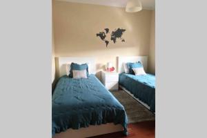 波尔图Oporto East House的一间卧室设有两张床,墙上挂有一张世界地图