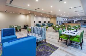 阿马里洛Holiday Inn - Amarillo East, an IHG Hotel的用餐室配有桌子和绿色椅子