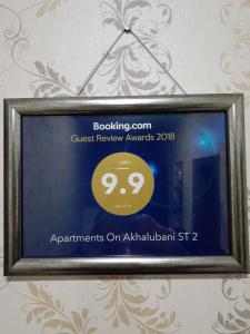 第比利斯Apartments on Akhalubani St 2的标牌,标牌上写着在框架中评奖的宾客