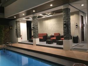 安吉利斯Andeo Suites的酒店大堂设有游泳池和家具