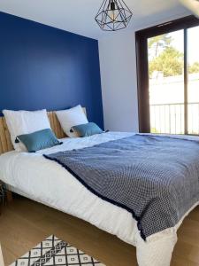 雷日卡普费雷Appartement cosy village de L'Herbe的一间卧室设有一张蓝色墙壁的大床