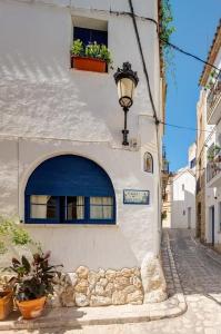 锡切斯La Casita - centro histórico y playa的白色的建筑,有蓝色的门和窗户