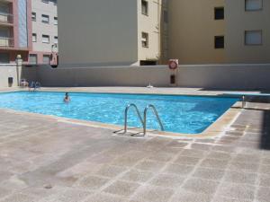 安波拉1ª LINEA DE MAR CON VISTA FANTÁSTICA的在建筑物游泳池游泳的人