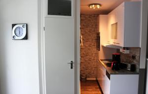 阿尔特瑙Ferienwohnung Sonnenblick的厨房配有白色橱柜和墙上的时钟