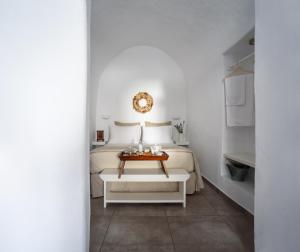 阿克罗蒂里Arvanitis Cave Village的白色卧室配有床和桌子
