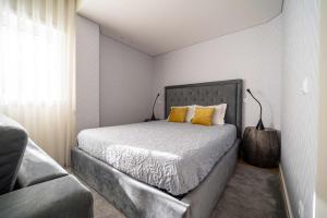 布拉加Bracara Guest House "Campo das Hortas"的一间卧室配有一张带黄色枕头的大床